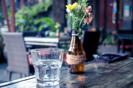 Glass of water on a wooden table. Bali island.の写真素材