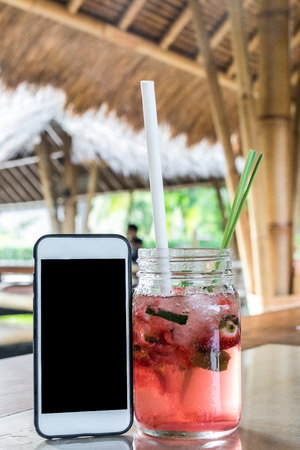 Glass of strawberry juice with soda on a wooden table. Tropical cafe background.の写真素材