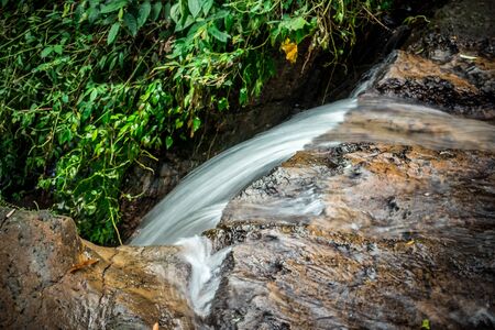 Small waterfall and stone with water motion in the jungle of Bali island.の写真素材