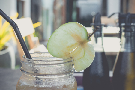 Close up of cold and fresh made apple juice in cafe of Bali island, Indonesia. Healthy drink in the glass. Sweet, delicious diet drink concept.の写真素材