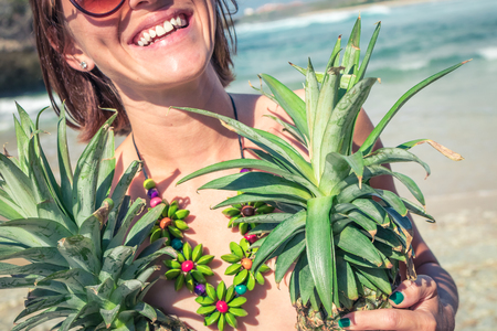 Tropical summer woman with pineapple. Outdoors, ocean, nature. Bali island paradise.の写真素材