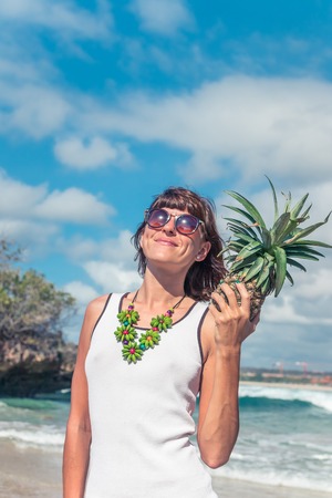 Tropical summer woman with pineapple. Outdoors, ocean, nature. Bali island paradise, Indonesia.の写真素材
