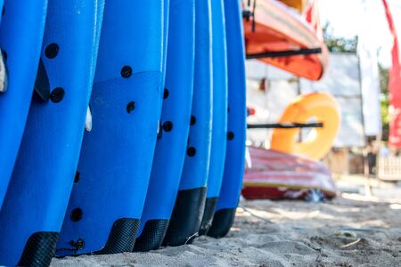 Set of blue surf boards in a stack by ocean. Bali. Surf boards on sandy Nusa Dua beach.の写真素材
