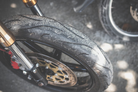 Closeup view of a rear wheel and drive wheel hub of a dirty, grunge motocross motorcycle, which lays...