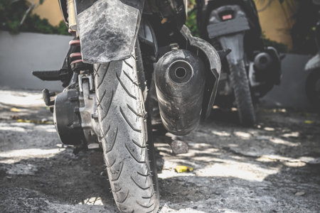 Closeup view of a rear wheel and drive wheel hub of a dirty, grunge motocross motorcycle, which lays...