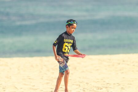 BALI, INDONESIA - OCTOBER 13, 2017: Boy walking on the beach of Bali island, Indonesia. Street photography, lifestyle.のeditorial素材