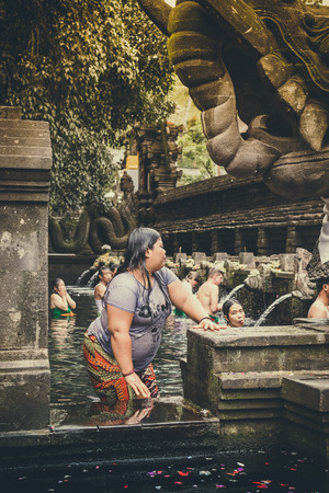 BALI, INDONESIA - DECEMBER 5, 2017: Holy spring water. People praying in the Tirta Empul temple. Bali, Indonesia.のeditorial素材
