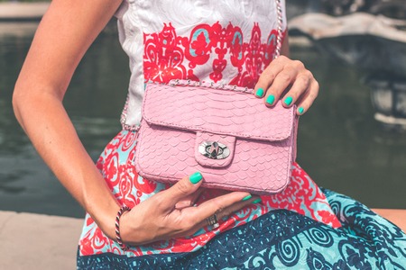 Woman hands with luxury handmade snakeskin leather handbag. Python snake fashionable handbag. Outdoors, Bali island.の写真素材