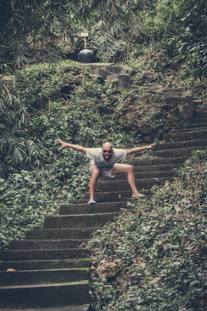 BALI, INDONESIA - JANUARY 10, 2018: Man Touristshaving fun on stairs, road from the beach. Tropical...