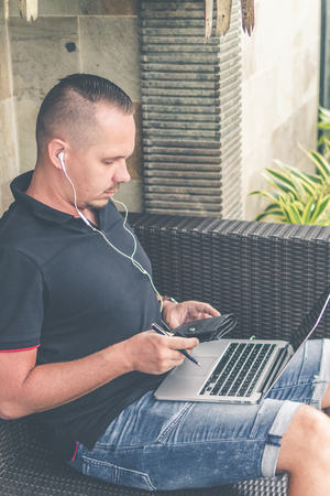 Man doing online shopping with credit card, laptop and luxury snakeskin python wallet. Man online shopping concept.の写真素材