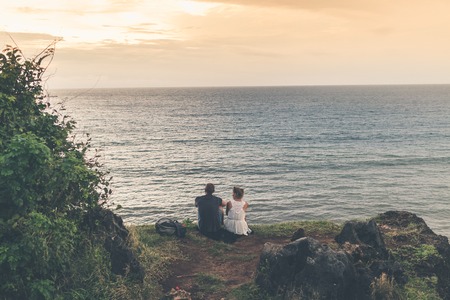 A couple is standing on the edge of mountain on a tropical Bali island.の写真素材