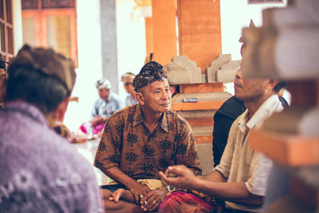 BALI, INDONESIA - APRIL 13, 2018: Group of balinese men playing cards sitting on the floor. Bali island.のeditorial素材