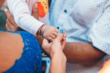 Woman hand holding baby hand. European and asian hands.の写真素材