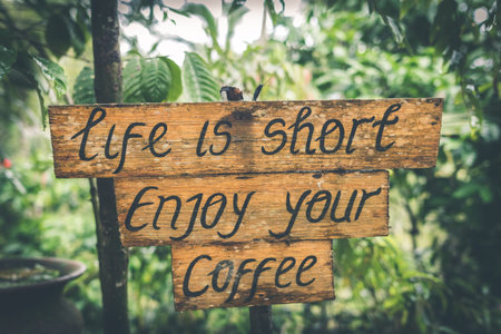 Life is short enjoy your coffee text on a wooden plate in the tropics of Bali island, Indonesia.の写真素材