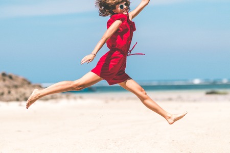 Woman Jumping In The Air On a Tropical Beach of Bali island.の写真素材