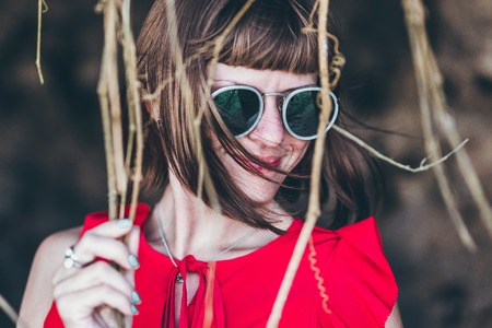 Close up shot of stylish young woman in sunglasses smiling. Beautiful female model with copy space. Bali island.の写真素材