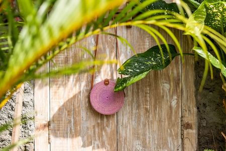 Fashionable stylish rattan bag in the tropical garden.の写真素材