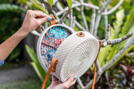 Fashionable stylish rattan bag in the tropical garden.