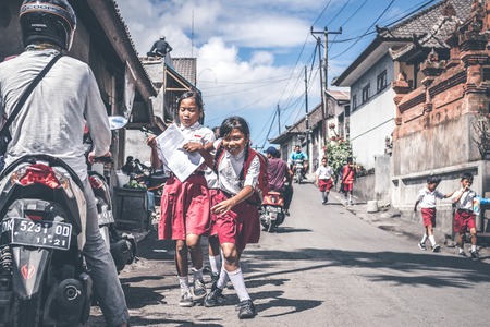 BALI, INDONESIA - MAY 23, 2018: Group of balinese schoolboys in a school uniform on the street in the village.のeditorial素材