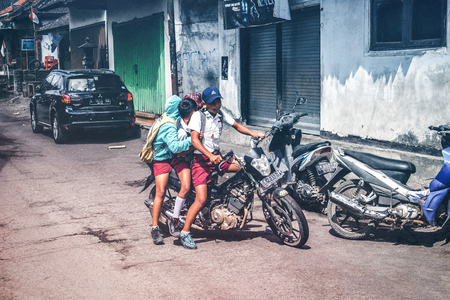 BALI, INDONESIA - MAY 23, 2018: Group of balinese schoolboys in a school uniform on the street in the village.のeditorial素材