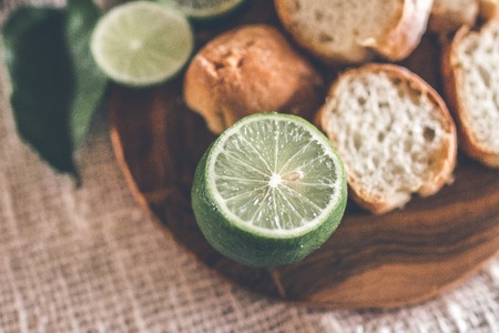 Sliced bread on wooden table with fresh and green lime.の写真素材