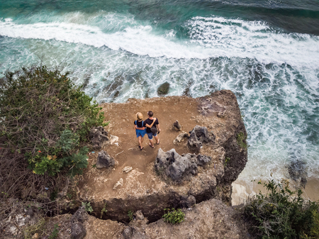 Aerial shot of couple on the cliff with ocean background.の写真素材