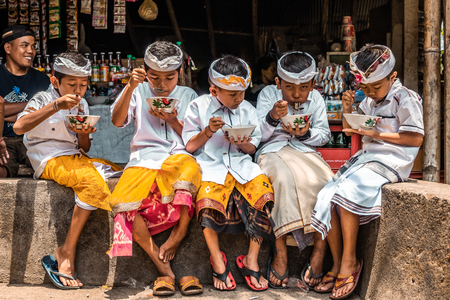 BALI, INDONESIA - SEPTEMBER 25, 2018: Balinese children in traditional clothes on a big ceremony in Tirta Empul Temple.のeditorial素材