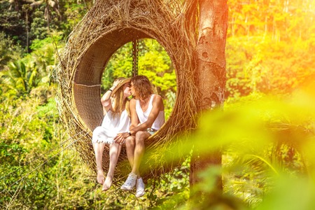 Traveler honeymoon couple in decorative nest the jungle of Bali island, Indonesia. Couple in the rainforest.の写真素材