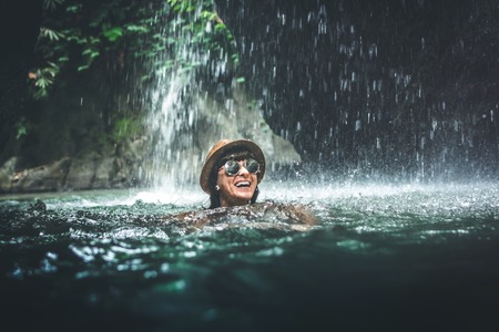 Young woman tourist swimming at the waterfall in jungles. Ecotourism concept image travel girl. Bali island.の写真素材