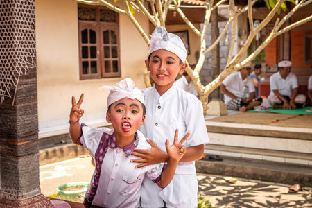 BALI, INDONESIA - OCTOBER 3, 2018: Balinese funny boys in traditional costume on a balinese family ceremony in desa Pejeng Kangi.のeditorial素材