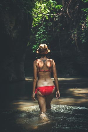 Young traveler woman in the jungle river. Rainforest of Bali island. Tourist adventure concept.の写真素材