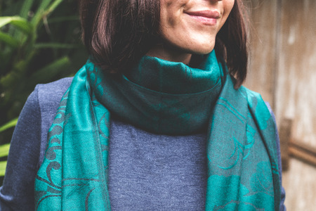 Woman wearing warm cashmere scarf on a tropical background. Asia.の写真素材