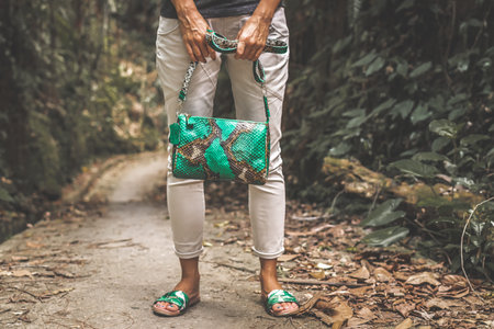 Woman with luxury snakeskin python handbag in the tropical forest. Bali island.の写真素材