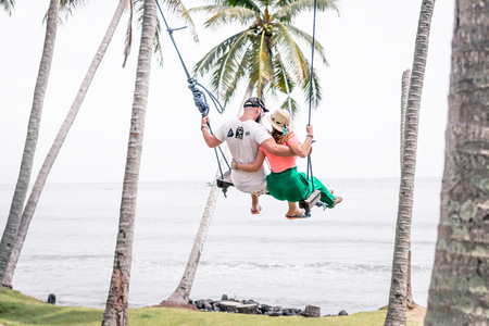 Young couple swinging on the tropical beach of Bali island, Indonesia.の写真素材