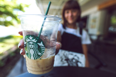 BALI, INDONESIA - FEBRAURY 19, 2019: Woman with Iced latte in Starbucks. Shopping mall in Kuta,...
