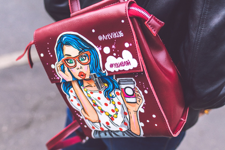 MOSCOW, RUSSIA - APRIL 10, 2019: Young woman with stylish hand painted backpack on the street. Modern City style.のeditorial素材