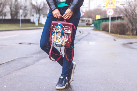 MOSCOW, RUSSIA - APRIL 10, 2019: Young woman with stylish hand painted backpack on the street....