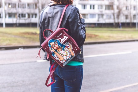MOSCOW, RUSSIA - APRIL 10, 2019: Young woman with stylish hand painted backpack on the street. Modern City style.のeditorial素材