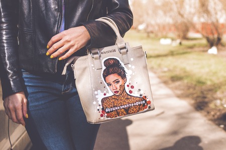 MOSCOW, RUSSIA - APRIL 20, 2019: Young woman with fashionable hand painted bag posing on the street.のeditorial素材