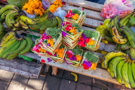 Traditional balinese handmade offering to gods on a morning market in Ubud. Bali island.の写真素材