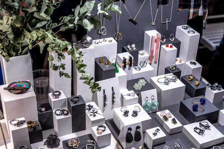 Variety of jewelry in store. Rings, bracelets, earrings and necklaces on stands for sale.の写真素材