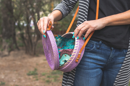 Woman with fashionable rattan bag on nature background. Female style, summer.の写真素材