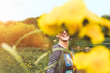Young pretty woman with yellow dandelions in the sunny summer park.の写真素材
