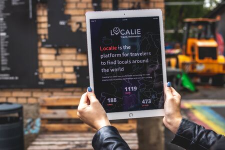 MOSCOW, RUSSIA - AUGUST 18, 2019: Woman hands holding iPad PRO tablet on the street background.のeditorial素材