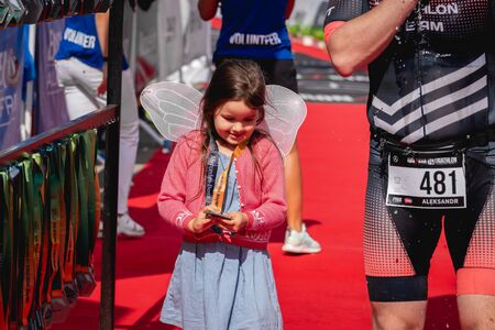 MOSCOW, RUSSIA - AUGUST 25, 2019: A girl on Finish line on Ironstar Crocus Fitness Triathlon 2019. Small girl meet her father.のeditorial素材