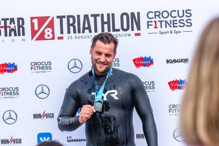MOSCOW, RUSSIA - AUGUST 25, 2019: Athletes with medals on IRONSTAR CROCUS FITNESS TRIATHLON 2019.のeditorial素材