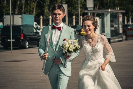 MOSCOW, RUSSIA - AUGUST 30, 2019: Bride and groom walking by city street. Wedding photo.のeditorial素材