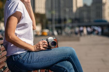Woman holding retro vintage camera outdoors. Old camera. Beautiful female photography.の写真素材