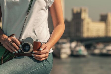 Woman holding retro vintage camera outdoors. Old camera. Beautiful female photography.の写真素材
