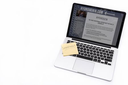 MOSCOW, RUSSIA - DECEMBER 10, 2019: Laptop and yellow note with investment letters isolated on a white background.のeditorial素材